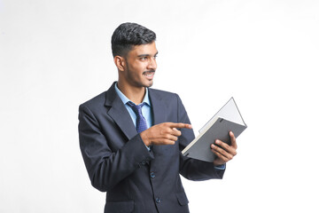 successful Young Indian businessman or employee wearing Suit and cheaking dairy on white background.