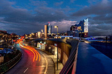 Blue hour in the port of Hamburg with the illuminated Elbphilharmonie and traffic in motion in...