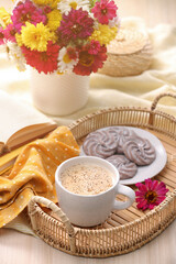 Cup of hot coffee, delicious cookies and beautiful bouquet on wooden table