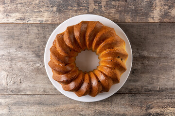 Traditional bundt cake piece with raisins on wooden table