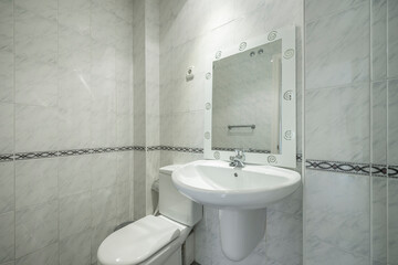 Conventional toilet with white sink, shower and mirror