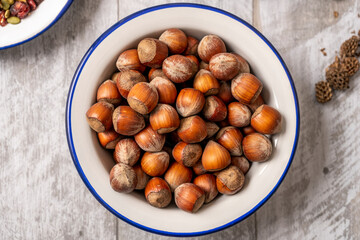 bowl of hazelnuts on gray wooden table