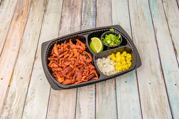 Home delivery tray with set of tacos al pastor with stew of meat, onion, mango, lime and coriander