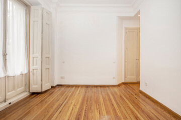 Room in apartment of building with vintage carpentry and pine wood flooring