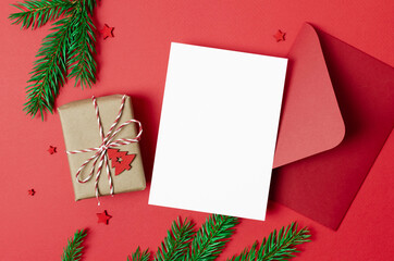 Christmas greeting or invitation card mockup with envelope and decorated gift box on red