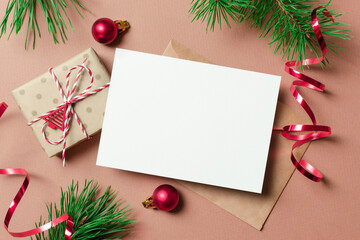 Christmas or New Year greeting card mockup with gift box, envelope and festive decorations
