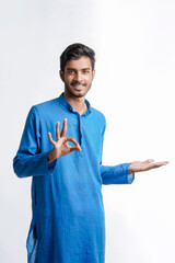 Indian man in tradition wear and giving expression on white background.