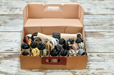 Organizing power and USB cables using empty toilet paper tubes in shoebox     
