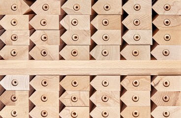 Huge stack of simple tables legs made of solid beechwood material stands in contemporary carpentry workshop as background