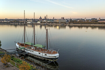 Fototapeta na wymiar Drone image over the Rhine on the Mainz riverbank with a sailing ship in the foreground in the morning