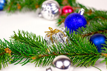 New year and christmas decoration with green fir tree branches and blue and silver shiny xmas traditional balls and baubles for greeting invitation cards.