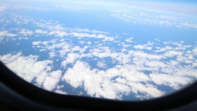Clouds moving in the sky. Panorama of the clouds and the terrestrial horizon taken from the porthole of a moving plane. Travel by plane with a view from the window