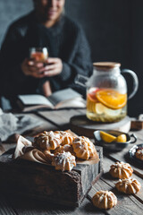 Woman is sitting with Hot tea with fresh grapefruit on wooden tablet. Healthy drink, Eco, vegan.
