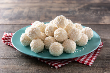 Homemade coconut balls on rustic wooden table. 