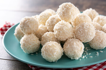 Homemade coconut balls on rustic wooden table. 