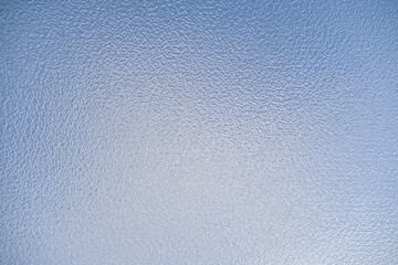 Close up of opaque frosted glass against a blue sky
