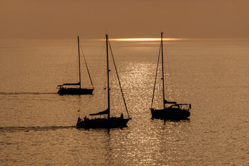 View on the sailboats in the ocean on the sunset in the golden light, close to the beach of Morro Jable on the Canary Island Fuerteventura.