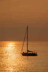 View on the sailboat in the ocean on the sunset in the golden light, close to the beach of Morro Jable on the Canary Island Fuerteventura.