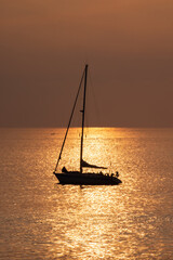 View on the sailboat in the ocean on the sunset in the golden light, close to the beach of Morro Jable on the Canary Island Fuerteventura.