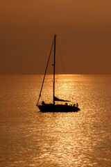 View on the sailboat in the ocean on the sunset in the golden light, close to the beach of Morro Jable on the Canary Island Fuerteventura.
