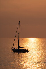 View on the sailboat in the ocean on the sunset in the golden light, close to the beach of Morro Jable on the Canary Island Fuerteventura.