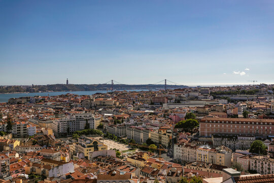 View of Lisbon downtown from Graca hilltop, view of April 25th bridge crossing Tagus river, Lisbon, Portugal.