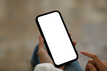 Woman using smartphone blank screen frameless modern design while lying on the sofa in home interior