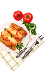 Portion of cabbage rolls stuffed with ground beef and rice with sour cream on a plate