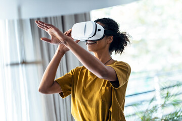 Modern mature entrepreneur woman using virtual reality headset and enjoying the moment in the office. - Powered by Adobe