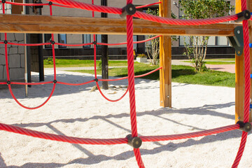 Fototapeta na wymiar rope jungle for kids. Detail of cross red ropes in safety climbing outdoor equipment.