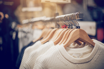 Sweaters on hangers. Shopping in store. Clothes on hangers in shop for sale - 471058020