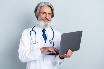 Photo of aged doctor use laptop type prescription eyewear treatment outbreak expert uniform isolated over grey color background