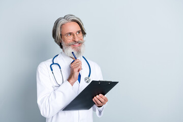 Photo of happy dreamy mature male doctor wear white coat glasses signing insurance looking empty space isolated grey color background