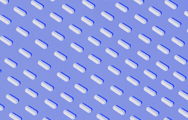 white pill capsules on blue background