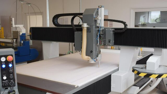 Industrial plotter working on large paper sheet - wide shot