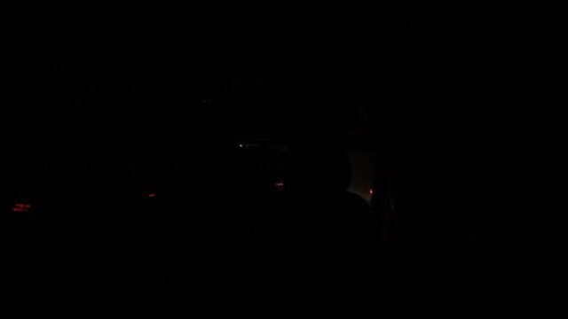 the view from the car while driving on the motorway at night in bad weather. Raindrops on the windshield, headlights from oncoming cars