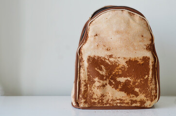 Simple backpack with leather being peeled off on a white counter
