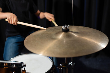 Close-up of drumsticks on a cymbal drum