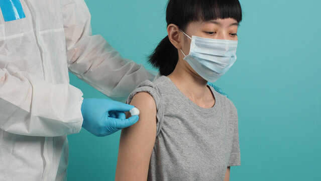 Vaccination Immunization Disease Prevention Concept. Woman In Medical Face Mask Getting Covid 19 Or Flu Vaccine. Doctor Using Cotton Before And After Make Injection. Coronavirus Vaccinated Woman.