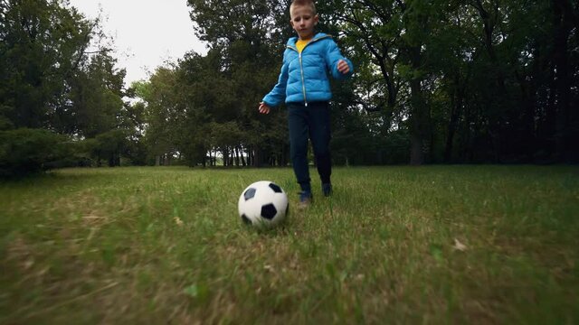 Boy training football dribbling in a field. Player is developing soccer dribbling skills. Ball control. Training, football, active lifestyle. Soccer.