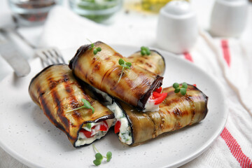 Delicious baked eggplant rolls served on table, closeup