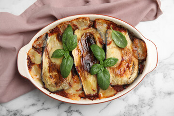Delicious eggplant lasagna in baking dish on white marble table, top view