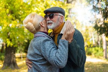 Portrait of happy senior couple dancing in park