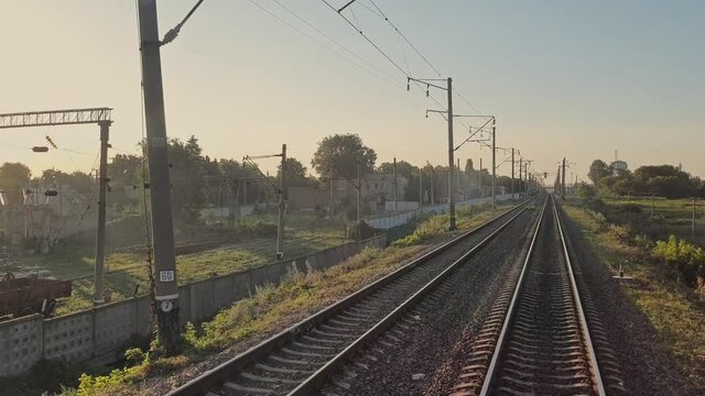 Train in motion. Railway. The train passes by the industrial area. View of the rails. Departure from the station. Trips. Tourism.