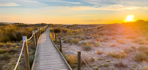 beautiful wooden path to the beach at sunset