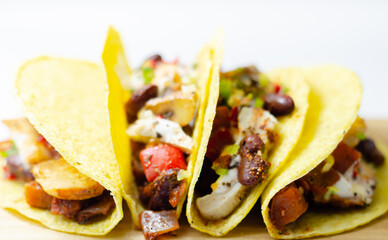 Mexican tacos shells with chicken and red kidney beans, onion,  red and green peppers, and salsa sauce