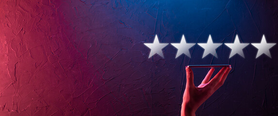 Man holds smart phone in hands and gives positive rating, icon five star symbol to increase rating...