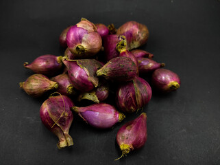 Photo of a pile of shallots isolated on a black background