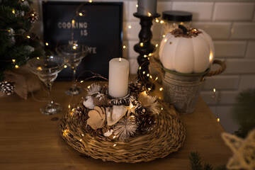 Christmas Elegant White Candle on a bokeh background, Christmas decor at home in the kitchen, Holiday Dining Table in Gold