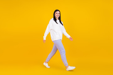 Fototapeta na wymiar Full length photo of positive lady youngster step fall millennial good cloth concept isolated over shine yellow color background